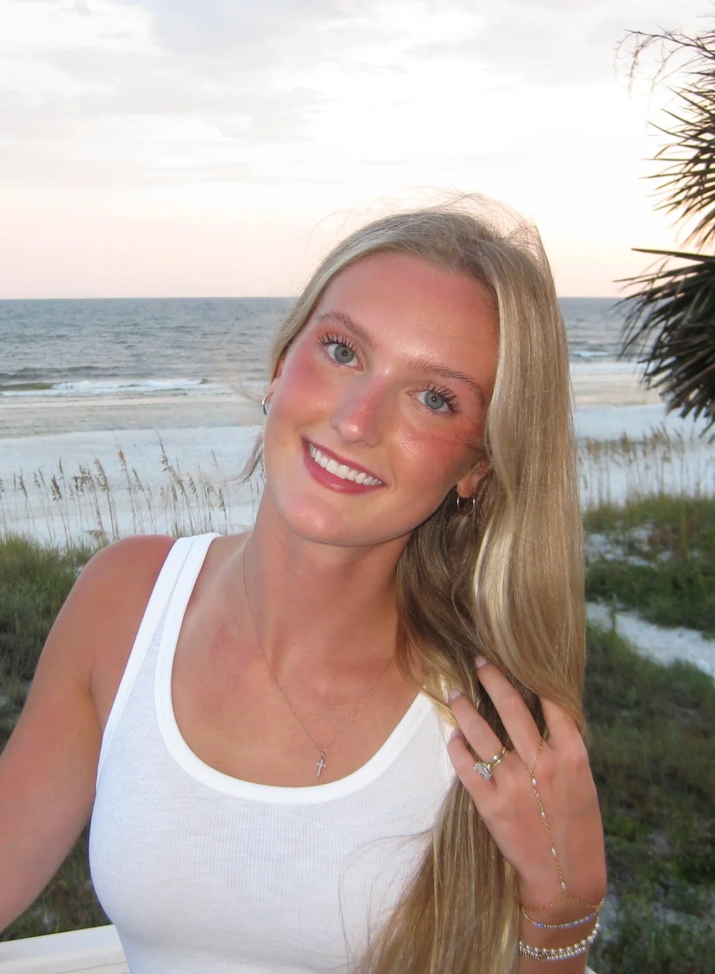 Shelby, the artist behind Shelby Jo Art, smiling on the beach at sunset